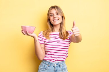 Güzel sarışın kız gururlu, olumlu gülümsüyor. boş kase kavramı