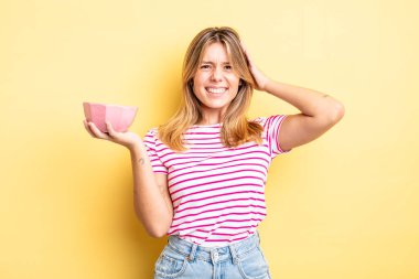 Güzel sarışın kız stresli, endişeli ya da korkmuş, elleri başının üstünde. boş kase kavramı