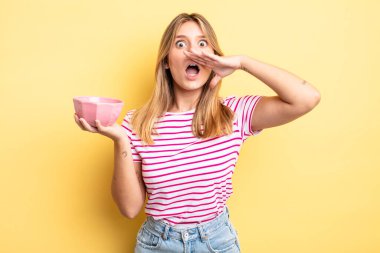 Güzel sarışın kız kendini mutlu hissediyor, elleri ağzının kenarında bağırıyor. boş kase kavramı