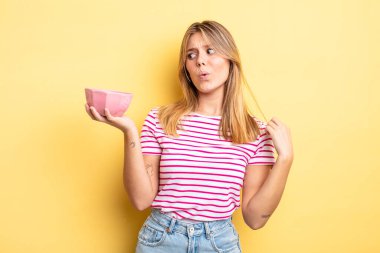 Güzel sarışın kız stresli, endişeli, yorgun ve hayal kırıklığına uğramış hissediyor. boş kase kavramı