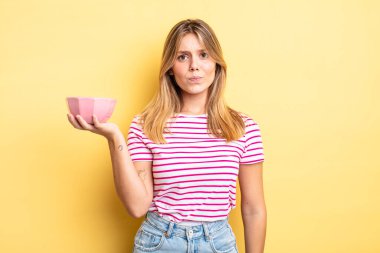 Güzel sarışın kız üzgün, üzgün ya da kızgın ve yana bakıyor. boş kase kavramı