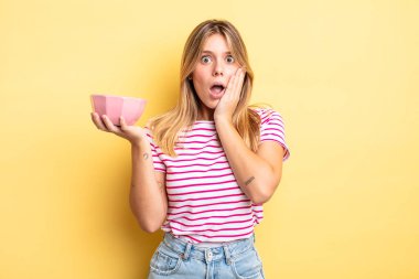 Güzel sarışın kız şok olmuş ve korkmuş hissediyor. boş kase kavramı