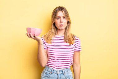 Güzel sarışın kız üzgün ve mızmızlanıyor. Mutsuz bir bakışı var ve ağlıyor. boş kase kavramı