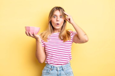 Güzel sarışın kız şaşırmış görünüyor, yeni bir düşünce, fikir ya da konsept fark ediyor. boş kase kavramı