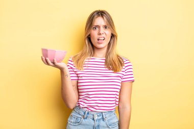 Güzel sarışın kız şaşkın ve şaşkın hissediyor. boş kase kavramı