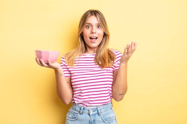 Güzel sarışın kız şok olmuş ve şaşırmış hissediyor. boş kase kavramı