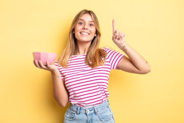 Güzel sarışın kız bir fikri fark ettikten sonra mutlu ve heyecanlı bir dahi gibi hissediyor. boş kase kavramı