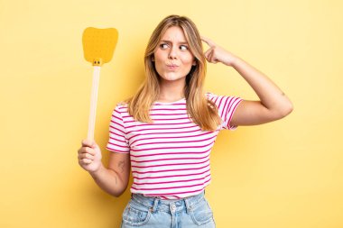 Güzel sarışın kız şaşkın ve kafası karışık, kaşınan bir kafa hissediyor. Öldürme konsepti