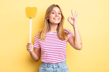 Güzel sarışın kız kendini mutlu hissediyor, iyi bir jestle onaylıyor. Öldürme konsepti