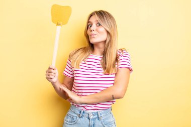 Güzel sarışın kız omuz silkiyor, kafası karışık ve kararsız. Öldürme konsepti