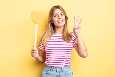 Güzel sarışın kız gülümsüyor ve arkadaş canlısı görünüyor, üç numarayı gösteriyor. Öldürme konsepti