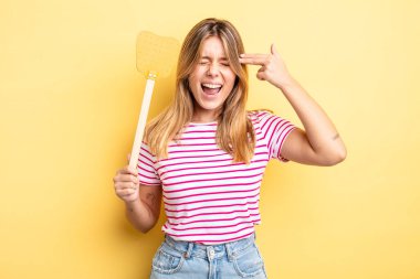 Güzel sarışın kız mutsuz ve stresli görünüyor, intihar jesti silah işareti yapıyor. Öldürme konsepti