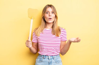 Güzel sarışın kız şaşırmış ve şok olmuş görünüyor. Çenesi düşmüş ve elinde bir nesne var. Öldürme konsepti