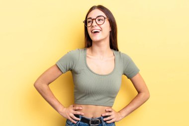 İspanyol güzel kadın mutlu, neşeli ve kendinden emin görünüyor, gururla gülümsüyor ve iki elini de kalçasında istiyor.