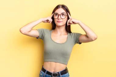 Hispanik güzel bir kadın kafası karışık ya da şüpheci, bir fikre odaklanmış, çok düşünüyor, kenarda boşluğu kopyalamak istiyor.