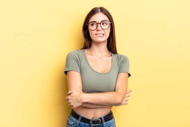 Hispanik güzel kadın şüpheye düşüyor ya da düşünüyor, dudağını ısırıyor ve kendini güvensiz ve gergin hissediyor, kenarda yer arıyor.