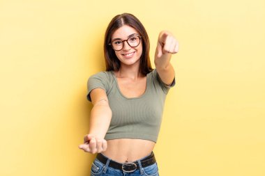 İspanyol güzel kadın mutlu ve kendinden emin, kamerayı iki eliyle gösteriyor ve gülüyor, seni seçiyor.