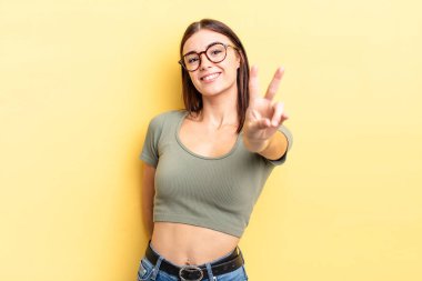 İspanyol güzel kadın gülümsüyor ve mutlu görünüyor, kaygısız ve olumlu, zafer ya da barış işareti yapıyor.