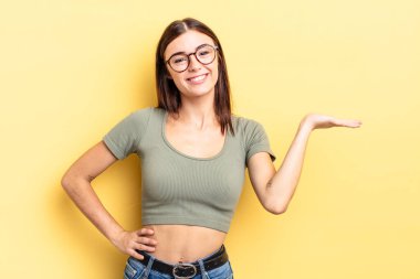 İspanyol güzel kadın gülümsüyor, kendinden emin, başarılı ve mutlu hissediyor, fotokopi alanında fikir veya konsept gösteriyor.