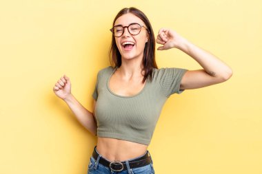 İspanyol güzel kadın gülümsüyor, kaygısız hissediyor, rahat ve mutlu, dans ediyor ve müzik dinliyor, bir partide eğleniyor.