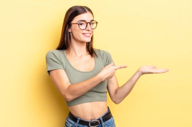 İspanyol güzel kadın gülümsüyor, mutlu, kaygısız ve tatmin olmuş hissediyor, fotokopi alanındaki konsepte ya da fikre işaret ediyor.