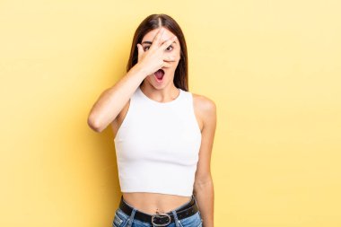 İspanyol görünümlü güzel bir kadın şok olmuş, korkmuş ya da korkmuş görünüyor. Yüzü elle kaplanmış ve parmaklarının arasından gizlice bakıyor.