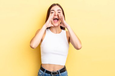 İspanyol güzel kadın mutlu, heyecanlı ve pozitif hissediyor. Elleri ağızda, bağırarak bağırıyor.