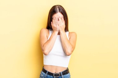 Hispanik güzel kadın üzgün, hayal kırıklığına uğramış, gergin ve depresif, iki eliyle yüzünü kaplayan, ağlayan
