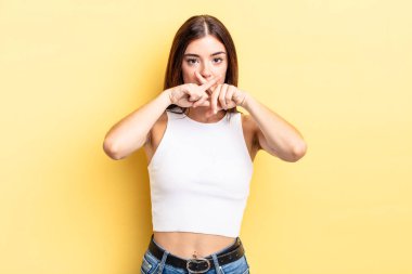 Latin kökenli güzel bir kadın ciddi görünüyor ve iki parmağının önde olması hoşnutsuzca karşılıyor. Sessizlik istiyor.