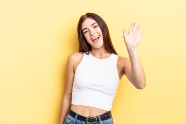 İspanyol güzel kadın mutlu ve neşeyle gülümsüyor, el sallıyor, seni selamlıyor ya da veda ediyor.