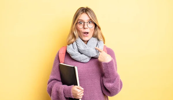 かなりブロンドの女の子がショックを受けて口を開けて驚いてる自分を指してる 学生のコンセプト — ストック写真