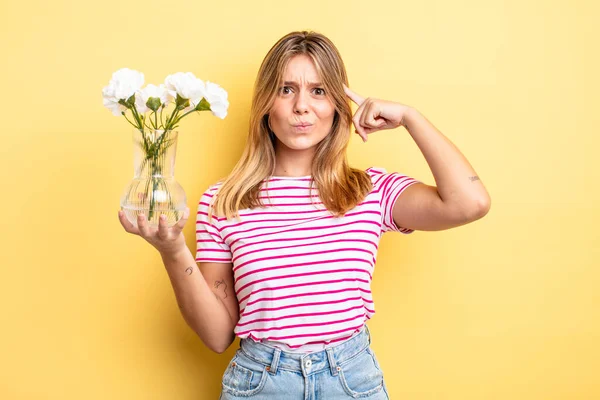 Güzel sarışın kız şaşkın ve şaşkın hissediyor, senin deli olduğunu gösteriyor. Dekoratif çiçek konsepti