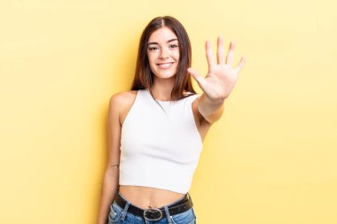 İspanyol güzel kadın gülümsüyor ve arkadaş canlısı görünüyor, 5 ya da 5 numarayı gösteriyor, elleri önde, geriye doğru sayıyor.