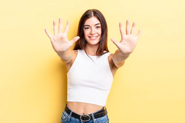 İspanyol güzel kadın gülümsüyor ve arkadaş canlısı görünüyor, onuncu ya da onuncu numarayı gösteriyor, eli önde, geriye doğru sayıyor.