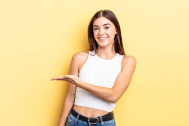 İspanyol güzel kadın neşeyle gülümsüyor, mutlu hissediyor ve fotokopi uzayda bir konsept gösteriyor.