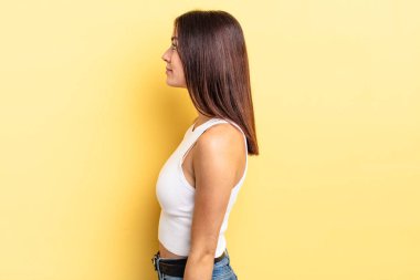 Latin kökenli güzel kadın profil görünümünde uzayı kopyalamaya çalışıyor, düşünüyor, hayal ediyor ya da hayal kuruyor.