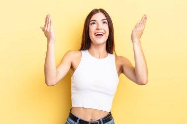 İspanyol güzel kadın kendini mutlu, şaşkın, şanslı ve şaşırmış hissediyor. Zaferi kutlarken iki elini havaya kaldırıyor.