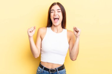 İspanyol güzel kadın son derece mutlu ve şaşırmış görünüyor, başarıyı kutluyor, bağırıyor ve zıplıyor.