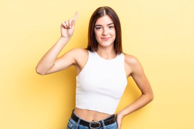 İspanyol güzel kadın neşeyle ve mutlu bir şekilde gülümsüyor, tek eliyle boşluğu dolduruyor.