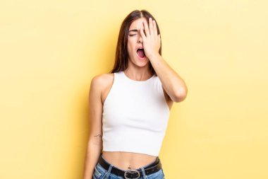 İspanyol güzel kadın uykulu, sıkılmış ve esniyor, baş ağrısı ve yüzünün yarısını kaplayan bir eliyle