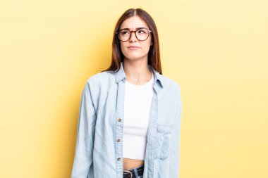 İspanyol güzel kadın şaşkın ve şaşkın görünüyor, merak ediyor veya bir sorunu çözmeye çalışıyor ya da düşünüyor.