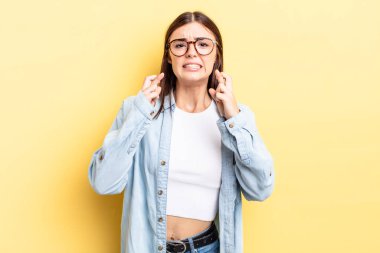 İspanyol güzel kadın endişeyle dua ediyor ve endişeli bir bakışla iyi şanslar diliyor.