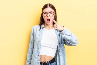 Kızgın, çılgın bir patrona benzeyen sinirli bir ifadeyle kameraya bakan İspanyol güzeli bir kadın.