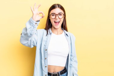 İspanyol güzel kadın kendini başarılı ve tatmin olmuş hissediyor, ağzı açık gülümsüyor, elle imza atıyor.