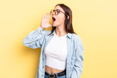 Latin kökenli güzel bir kadın öfkeyle ve yüksek sesle bağırıyor. Yan taraftaki boşluğu kopyalasın, eli ağzının yanında.