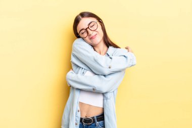 Hispanik güzel kadın aşık, gülümseyen, sarılan ve kendine sarılan, bekar, bencil ve benmerkezci.