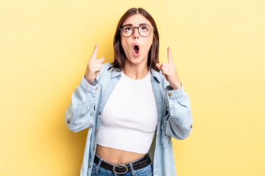 Hispanik güzel kadın şaşkınlık içinde ve ağzı açık. Şok olmuş ve şaşırmış bir bakışla yukarı bakıyor.