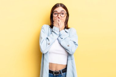 İspanyol güzel kadın mutlu ve heyecanlı, şaşırmış ve şaşırmış elleri ağızda, tatlı bir ifadeyle kıkırdıyor.