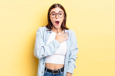 İspanyol güzel kadın şaşkın ve şaşırmış hissediyor, gülümsüyor, el ele tutuşuyor, mutlu ya da minnettarlık gösteriyor.