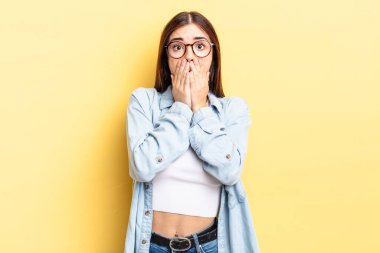 Hispanik güzel kadın endişeli, üzgün ve korkmuş hissediyor, elleriyle ağzını kapatıyor, endişeli ve berbat görünüyor.